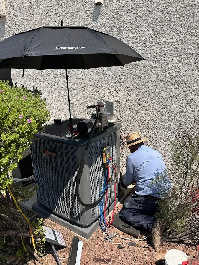 HVAC technician performing outdoor AC maintenance in Alpine